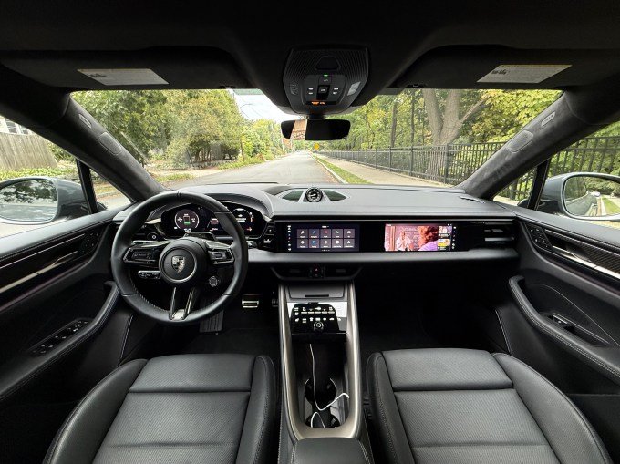 Three screens illuminate the dash of a Macan EV.
